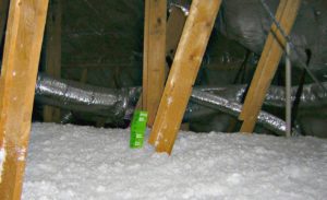 A carpet of fiberglass attic insulation